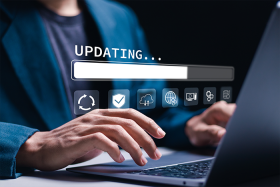 Man typing on a laptop with the words Updating written on the overlay
