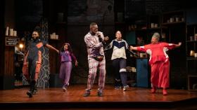 Five actors onstage, moving and waving their arms.