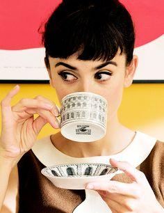 Audrey Hepburn drinking a cup of tea and looking at her extended pinky.