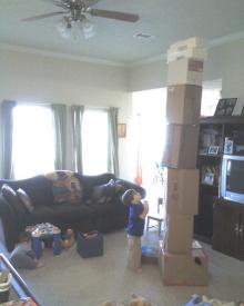 Picture of child looking up a gigantic stack of boxes